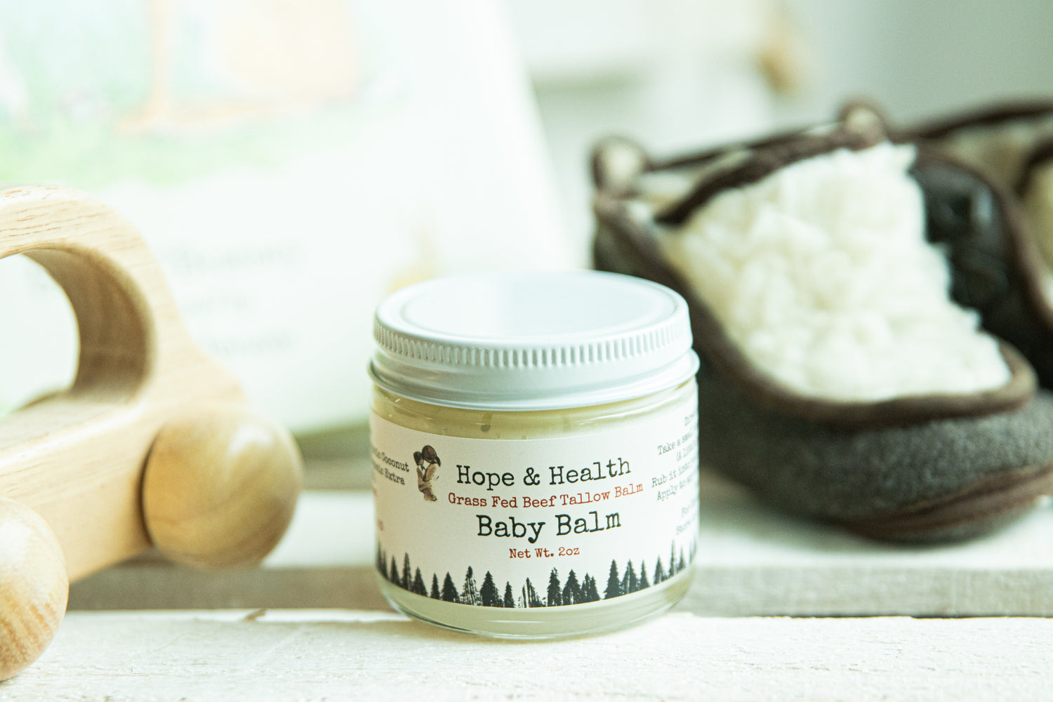 A 2-ounce glass jar filled with tallow-based baby balm, made from locally sourced grass-fed beef tallow from Sturgis Meats. The balm has a smooth, creamy texture and is designed to nourish and protect delicate skin.